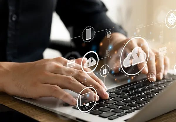 Hands on laptop keyboard with icons