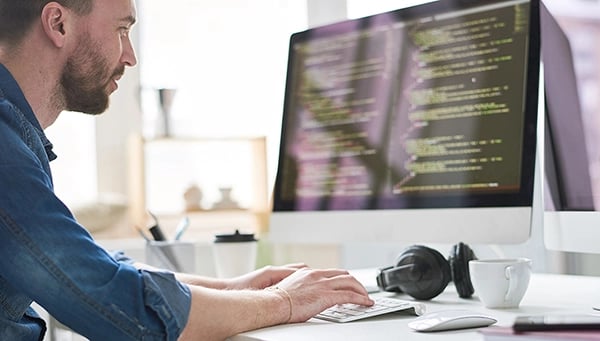 Developer writing code on desktop computer