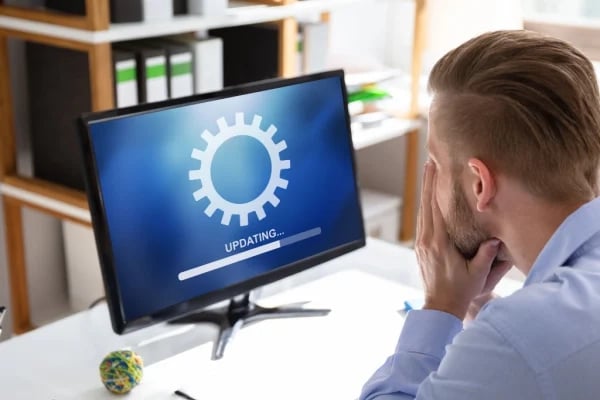 Man waiting for update on computer screen