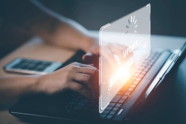 Hands on laptop with uploading icon