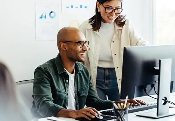Smiling developers looking at computer