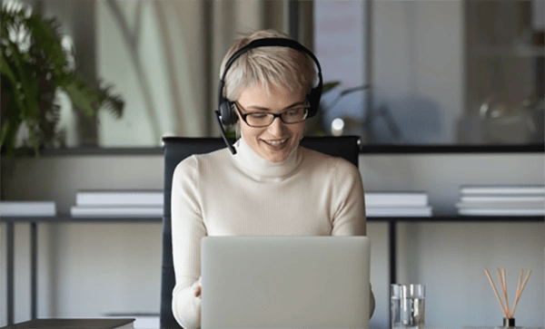 Woman smiling while working on laptop