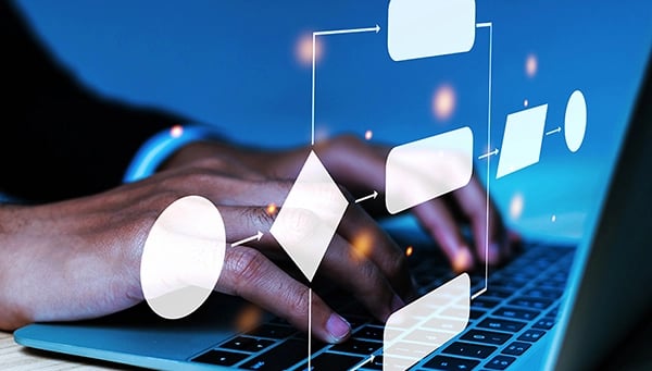 Hands on laptop with workflow icons